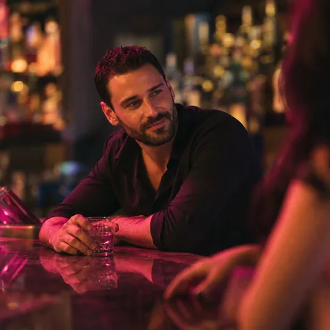 Man at a neon lit cocktail bar at night, illustrative photo, not a member