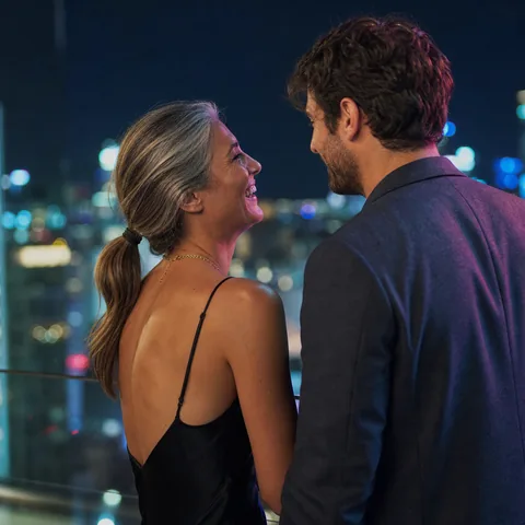 Woman and younger man talking at a rooftop lounge at night, illustrative photo, not a member